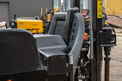 Ditch Witch JT24 operator seat, ROPS frame, safety decals, amber warning light, and hydraulic components shown close-up
