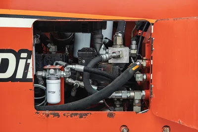 Ditch Witch JT4020 MACH 1 open engine compartment showing hydraulic pump, manifold, hoses, filter, and fittings.