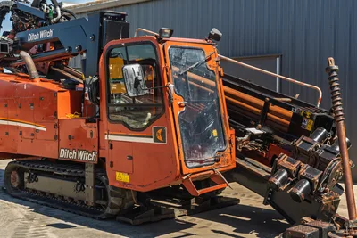 2014 Ditch Witch JT100 Mach 1 HDD rig, operator cab close-up, loaded drill pipe, carriage assembly, rubber tracks, work-worn condition