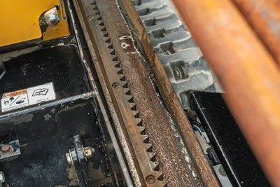2018 Vermeer D8x12 HDD drill rack and thrust/pullback gear rack close-up showing wear, rubber track, and warning decals