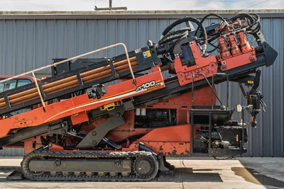 2014 Ditch Witch JT100 Mach 1 HDD rig, side profile, elevated drill frame with loaded pipe rack, hydraulic components, rubber tracks