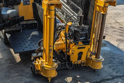 2016 Vermeer D23x30 S3 drill frame close-up showing yellow hydraulic cylinders, vise assembly, and worn paint on carriage