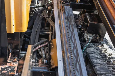 2020 Vermeer D24x40 S3 drill frame rack-and-pinion thrust system, hydraulic hoses, and rubber track close-up