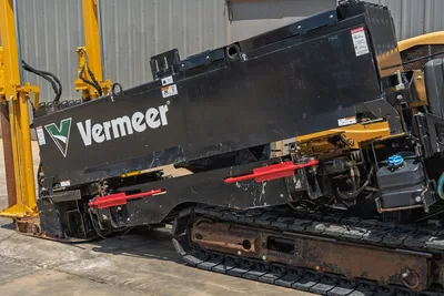 2021 Vermeer D24x40 S3 HDD drill frame side view showing black carriage, red pipe holders, rubber tracks, hydraulic lines