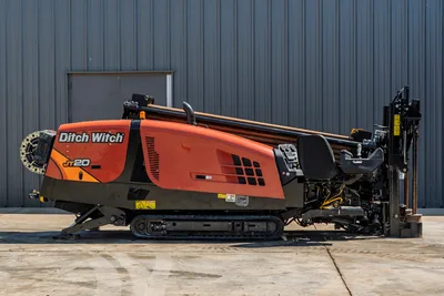 Side view of 2018 Ditch Witch JT20 HDD drill featuring rubber tracks, operator seat, engine housing, and drill pipe rack.