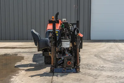 Rear view of 2018 Ditch Witch JT10 drill, showing open operator station, drill rack, hydraulic lines, and rubber tracks.