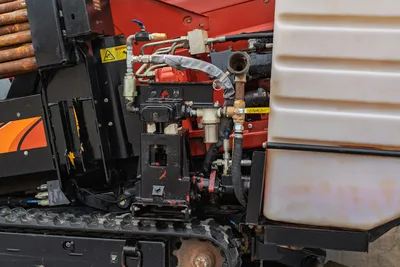 2016 Ditch Witch JT9 mud system closeup showing fluid manifold, Apollo valve, hoses, filters, drill pipe rack, and rubber tracks