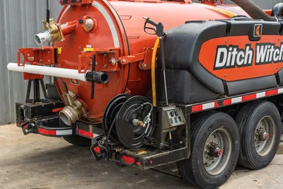 2023 Ditch Witch HX50 mud mixer rear quarter view showing vacuum tank, hose reel, cam-lock fittings, spray wand, and tandem axle