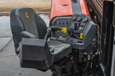 Ditch Witch JT20 operator cab with control console, gauges, joystick, switches, and Ditch Witch-branded seat, side view