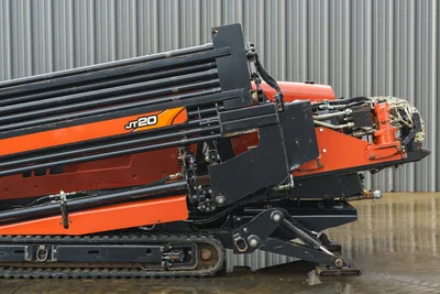 2015 Ditch Witch JT20 HDD drill rig, side angle showing loaded drill pipe rack, carriage, hydraulics, and rubber tracks.