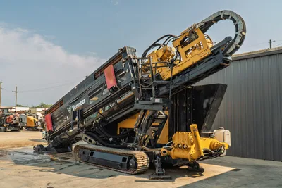 2017 Vermeer D100x140 S3 HDD drill angled upright, showing drill frame, pipe carousel, hydraulic system, tracks, and mud pump