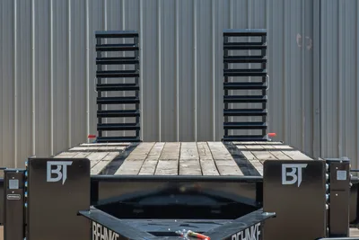 Behnke FB8X30SDPT-40L trailer rear view showing wood deck, dual upright steel ramps in raised position, BT logos on fenders