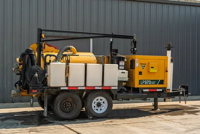 2024 Vermeer LP573SGT vacuum excavator, side profile showing trailer, dual axles, suction hoses, and engine compartment.