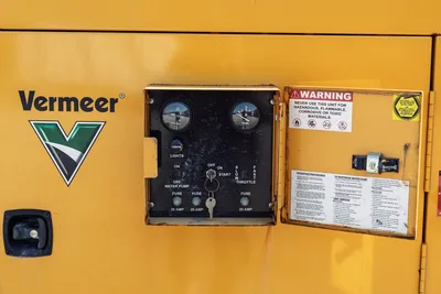2024 Vermeer LP573SGT control panel with hour meter, fuel gauge, throttle, ignition switch, and warning labels on door.
