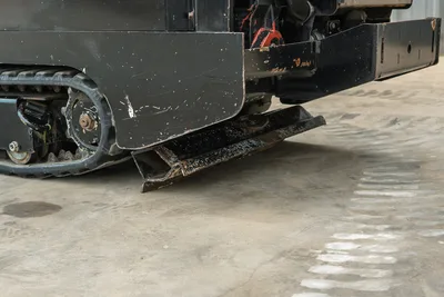 2018 Vermeer D8x12 HDD drill close-up of rubber track undercarriage and ground anchor blade, wear-marked steel frame