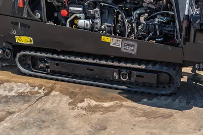 2022 Ditch Witch JT20 rubber track undercarriage and exposed engine compartment with hydraulic components, close-up side view