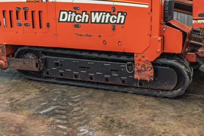 Side profile of 2008 Ditch Witch JT4020 MACH 1 engine compartment and steel track undercarriage with visible wear.
