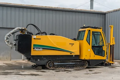 Side view of 2017 Vermeer 40x55 S3 HDD drill, featuring enclosed cab, tracks, drill pipe rack, and engine compartment.
