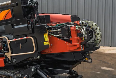 Close-up side view of 2018 Ditch Witch JT20 drill-head carriage, hydraulic manifold, feed chain, and undercarriage tracks.