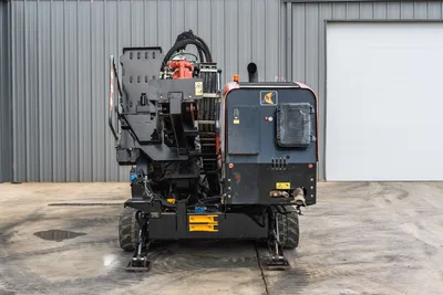 2021 Ditch Witch JT28 HDD drill, front view, showing carriage, red rotary drive, hydraulic hoses, engine enclosure, rubber tracks, and outriggers.