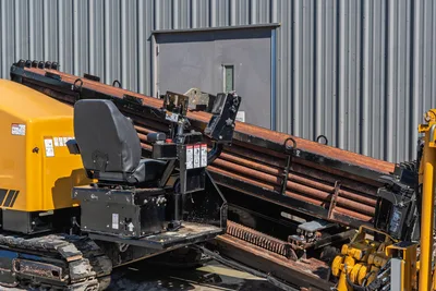 2021 Vermeer D40x55 S3 operator seat, drill pipe rack loaded with 2.625" HDD pipe, carriage assembly, rubber tracks visible