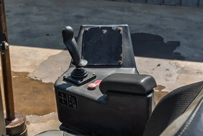 2022 Ditch Witch JT20 operator console showing joystick control, red stop button, armrest, and worn control panel with decals