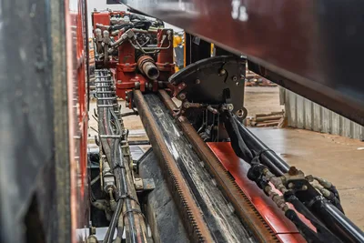 Ditch Witch JT20 HDD rig side profile showing red frame, engine compartment, hydraulic systems, and drill pipe rack assembly
