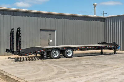 2026 Behnke FB8X30SDPT-40L drop-deck trailer, full side view, black steel frame, tandem axles, fold-down ramps, reflective markers, gooseneck hitch