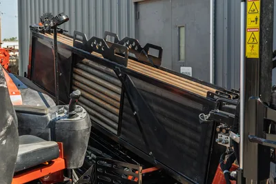 2020 Ditch Witch JT24 operator station, drill pipe rack, mesh screen, and joystick controls, side perspective, clean condition.
