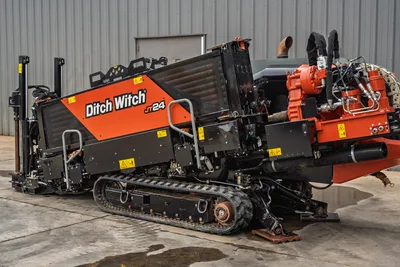 2024 Ditch Witch JT24 HDD rig, 3/4 rear view, rubber tracks, exposed red engine, drill frame angled, caution labels visible
