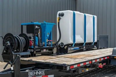 Behnke TBCT2220ET-BT-R flatbed trailer with blue mud mixer, SL500 poly tank, hose reel, and wood deck, rear 3/4 view