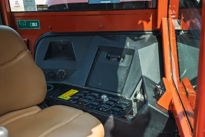 2017 Ditch Witch JT30 cab interior showing operator controls, rocker switch panel, tan seat, electrical connectors, and safety decals