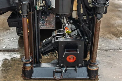2016 Ditch Witch JT9 drill frame close-up showing vise assembly, anchor posts, hydraulic lines, and spindle with red saver sub