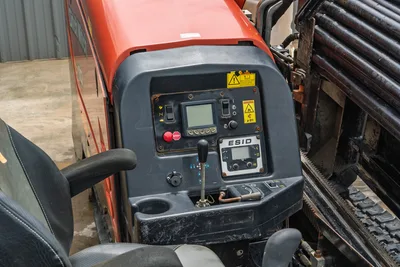2018 Ditch Witch JT10 HDD control console, operator seat, ESID display, and drill pipe rack. High-angle drill equipment view.