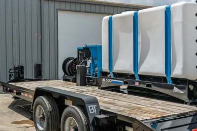 Behnke CBCT2324E-BT-R flat deck trailer with Straightline SL500 mud mixer, dual white poly tanks, blue frame, hose reel, tandem axle