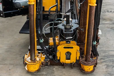 2016 Vermeer D23x30 S3 drill frame close-up showing vise assembly, hydraulic lines, anchor posts, and worn yellow paintwork