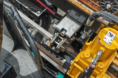2024 Vermeer D20x22 S3 drill frame carriage close-up showing vise clamp, hydraulic lines, wear marks, and yellow rotary drive housing