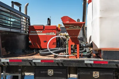 2015 International 7400 mud truck bed with Ditch Witch FM25 mixer, FM13v hopper, plumbing manifold, hoses, and white water tank
