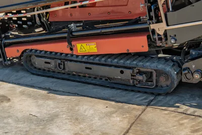 2018 Ditch Witch JT20 side view highlighting rubber tracks, frame, hydraulic lines, and drill pipe carriage components.