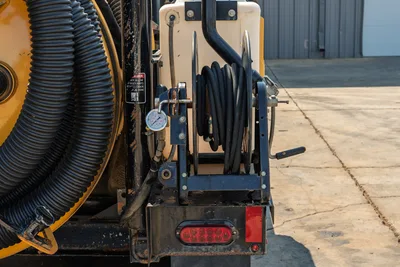 2024 Vermeer LP573SGT vacuum excavator rear view showing hose reel, water tank, vacuum suction hose, and pressure gauge.