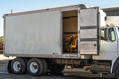 2000 Freightliner FL80 mud truck with Morgan box, side door open, displaying internal fluid mixing equipment components.