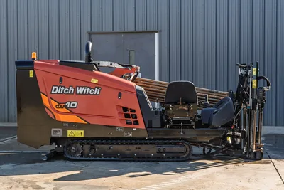 Ditch Witch JT10 HDD rig, side profile, red/orange cab, tracked undercarriage, drill pipe bundle, operator station, 9,000 lbs thrust, 688 hours