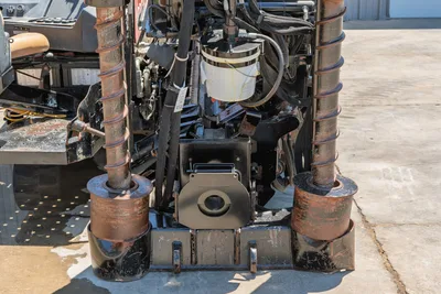 2018 Ditch Witch JT30 All Terrain rear carriage close-up showing dual vise jaws, pipe spinner, hydraulic hoses, and wear-marked drill pipe sections