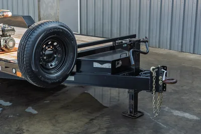 2023 MAXX-D C6X trailer tongue detail showing coupler, safety chains, tongue jack, radial ST tire, and black steel frame