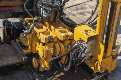 Close-up of dual-vise wrench system on 2009 Vermeer D36x50 Series II HDD drill rig, showing hydraulic lines and components.