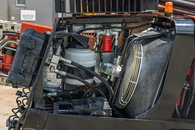 2023 Ditch Witch JT20 open engine compartment showing hydraulic filter, coolant reservoir, fan, and hose routing