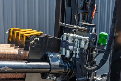 Ditch Witch JT20 drill pipe rack, hydraulic control valves, and green strobe light on heavy-duty directional drill frame.