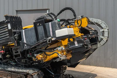 Rear angle view of Vermeer 24x40 Series II HDD drill showing drill pipe rack, hydraulic lines, fluid tanks, and steel tracks.