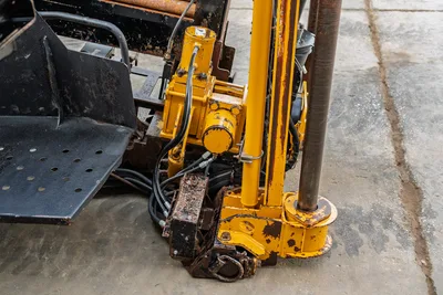 2016 Vermeer D23x30 S3 drill frame close-up showing hydraulic spindle, drill pipe, thrust frame, and operator step with wear