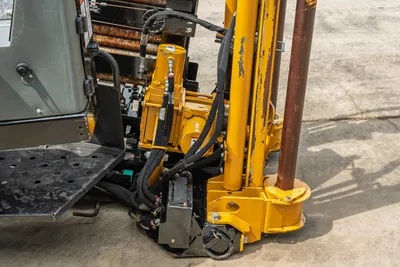 Vermeer D20x22 S3 drill carriage, vise assembly, hydraulic hoses, and loaded drill pipe rack shown at close range.